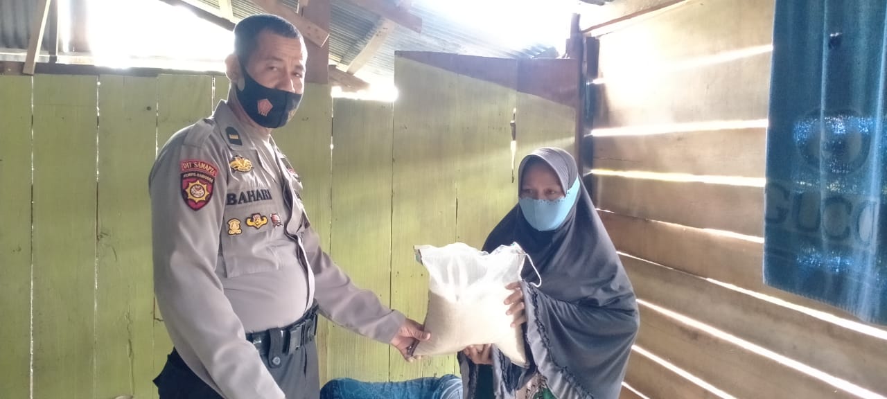 Berbagi Beras, Ipda Bahari Juga Himbau Warganya Tetap Terapkan Protokol Kesehatan