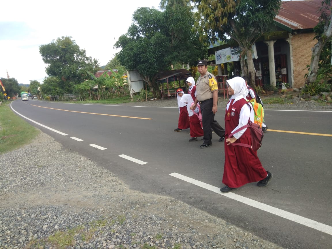 Pelayanan Prima Di Pagi hari Personil Polsek Binuang Polres Polman Sebrangkan Anak Sekolah.