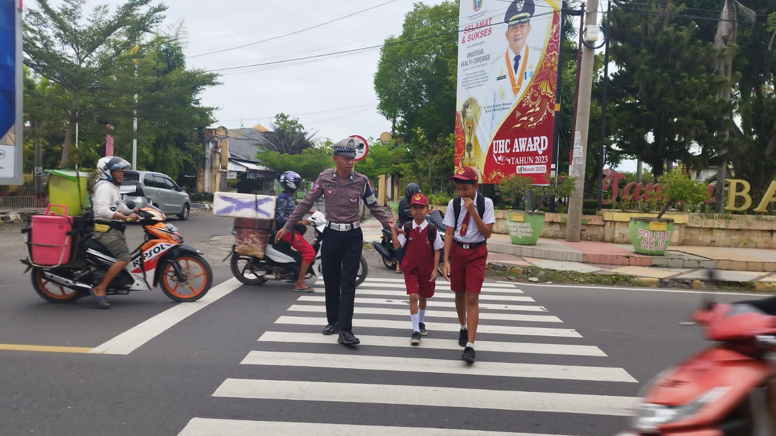 Personel Sat Lantas Polres Polman Bantu Anak Sekolah Menyebrang Jalan